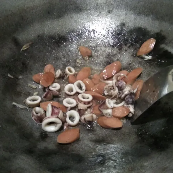 Tumis bawang putih, lalu masukkan cumi dan sosis, tambahkan garam.