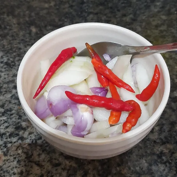 Belah timun memanjang empat bagian, buang bijinya dan potong-potong. Sementara bawang merah dipotong agak tebal. Masukkan timun, bawang merah dan cabe rawit kedalam larutan cuka. Aduk rata dan sisihkan.