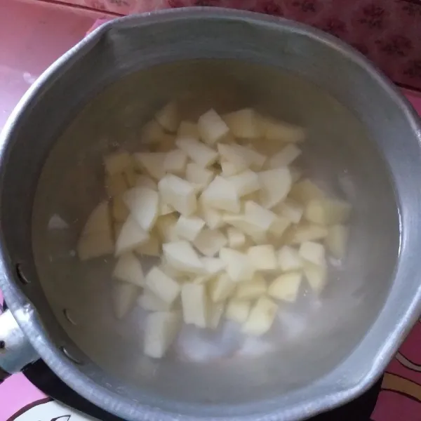 Panaskan air lalu rebus potongan kentang hingga matang. Sementara di panci lain rebus telur ayam.