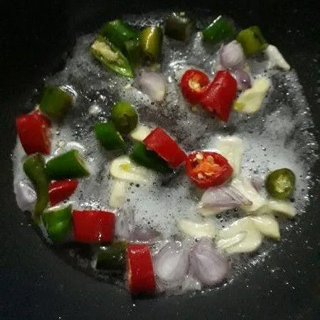 Panaskan minyak tumis cabe merah hijau dan bawang putih.