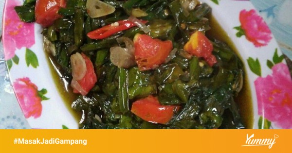 Proses memasak oseng genjer dengan bumbu yang sedang ditumis