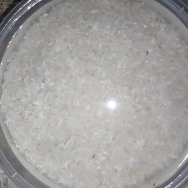 Rendam beras dengan air hingga menutupi beras, biarkan 15 menit dan tiriskan.