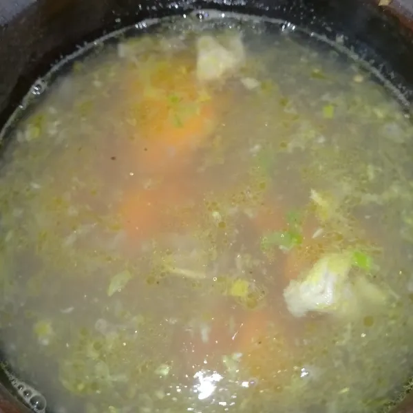 Masukkan tumisan bumbu dan wortel ke dalam air rebusan daging. Masak hingga wortel setengah matang.