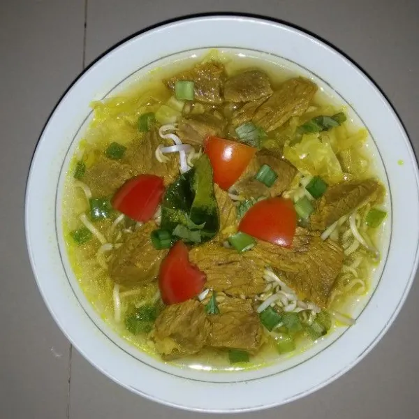 Siapkan mangkok saji. Masukan taoge, kubis, potongan daging sapi. Kemudian siram dengan kuah soto. Taburkan daun bawang, daun seledri, bawang goreng dan irisan tomat.