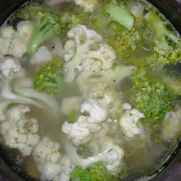 Masukkan brokoli dan bunga kol beserta garam dan kaldu sapi bubuk. Masak hingga sayuran matang.