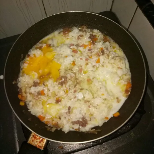 Masukkan nasi, aduk rata. Tuang susu dan telur, aduk cepat sampai tercampur rata. Angkat.