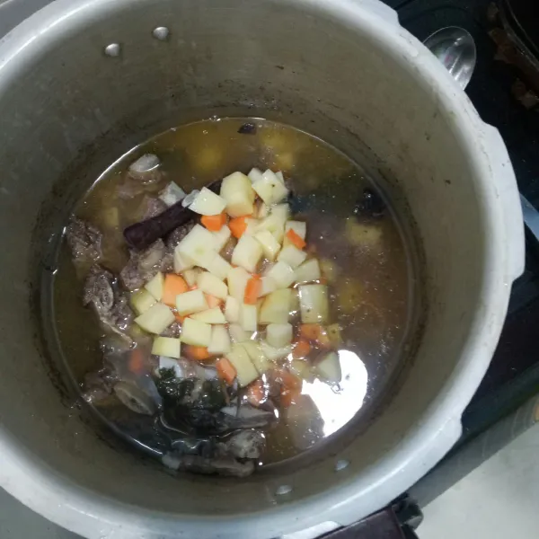 Setelah 30 menit dan uap keluar dari panci presto masukkan kentang dan wortel.
