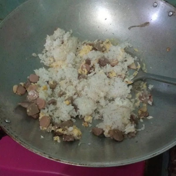Tambahkan nasi putih lalu aduk hingga tercampur rata.