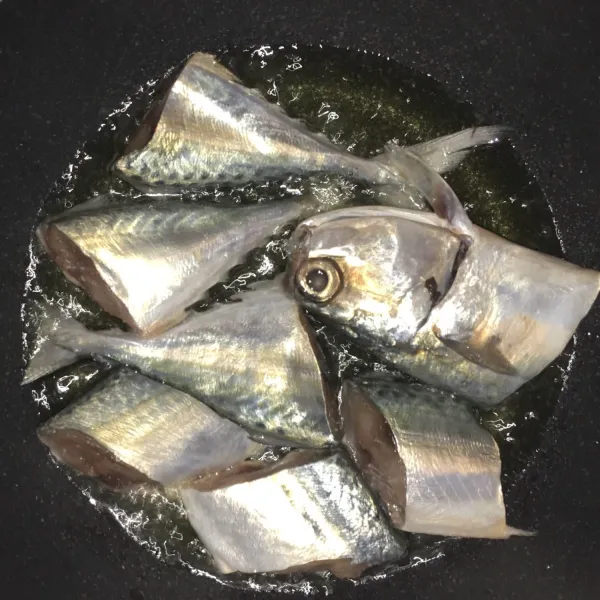 Goreng ikan kembung dengan minyak panas.
