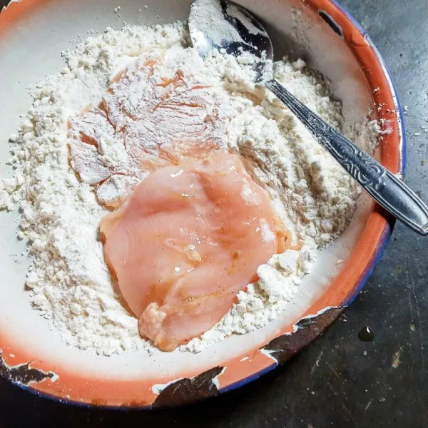 Masukkan ayam ke dalam tepung lalu baluri dengan tepung sampai rata