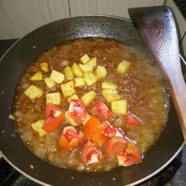 Masukkan kentang dan tomat. Masak sekitar 1 menit atau sampai tomat layu lalu angkat dan sajikan.