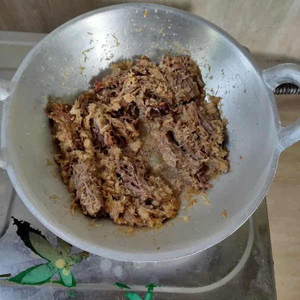 Tambahkan garam dan gula merah, gunakan api kecil, masak sambil diaduk-aduk sampai kuah menyusut dan kelapa dan daging tampak kering kecoklatan. Angkat. Tuang dalam wadah saji, sajikan.