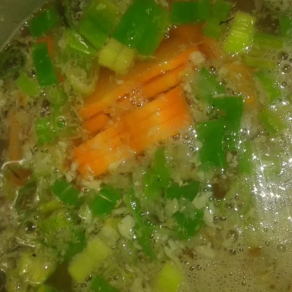 Tambahkan wortel dan irisan daun bawang. Beri kaldu jamur, gula dan garam. Koreksi rasa sampai pas.