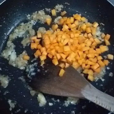 Tumis bawang merah, bawang putih, wortel dan sosis agak lama.