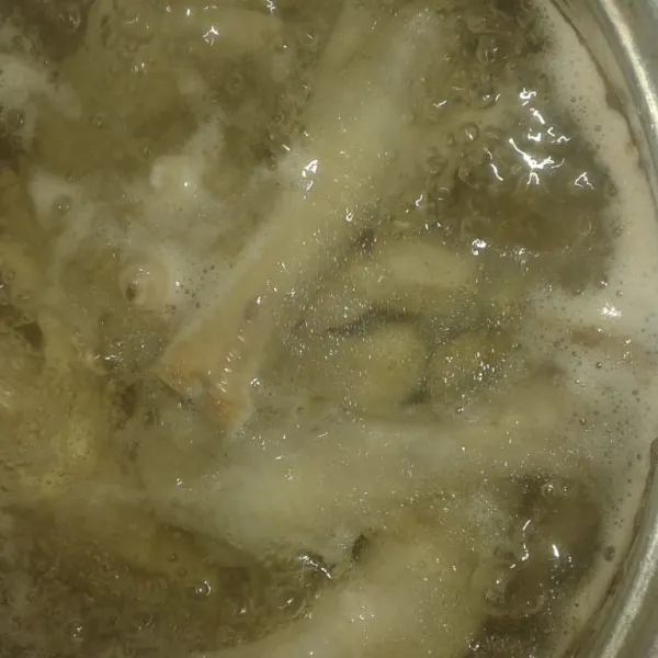 Rebus ceker ayam sampai empuk, buang kotoran yang mengambang di atas.