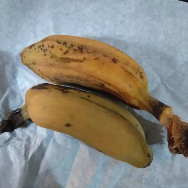 Hancurkan 2 buah pisang menggunakan garpu.