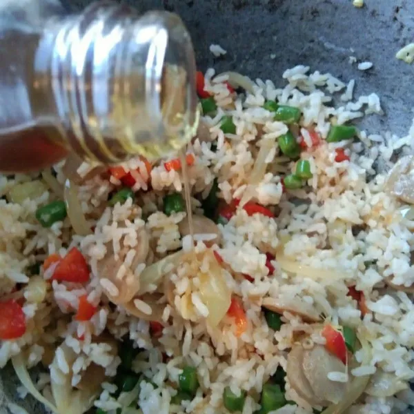 Tambahkan minyak wijen, masak hingga nasi goreng matang.
