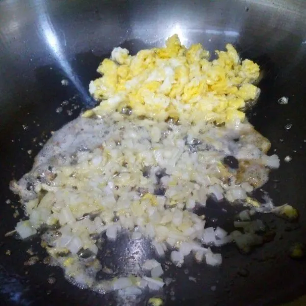 Buat orak arik telur, sisihkan di pinggir wajan. Masukkan bawang putih dan bawang bombay, tumis sampai harum sedap.