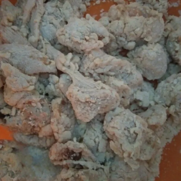 Masukkan ayam yang sudah dibumbui tadi, aduk rata, dan agak ditekan tekan supaya tepung menempel pada ayam, sisihkan.
