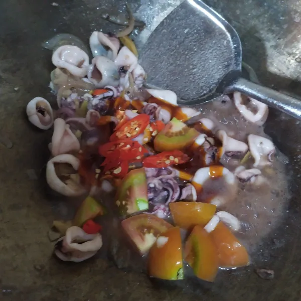 Lalu masukkan saus pedas, irisan cabai dan tomat, aduk dan masak sebentar saja sampai cumi matang kurang lebih selama 3 menit, angkat dan siap disajikan.