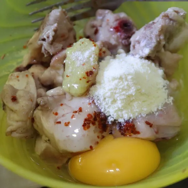 Siapkan potongan ayam, beri cabai bubuk, telur dan penyedap rasa.