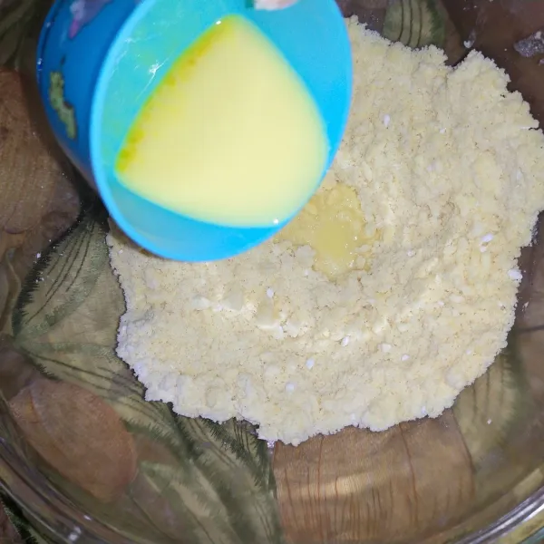 Kocok kuning telur dengan 2 sdm air, tuang kedalam adonan kulit. Cukup campurkan hingga rata, jangan sampai kalis. Lalu tutup adonan dengan plastik wrap. Simpan di dalam kulkas 20 menit.