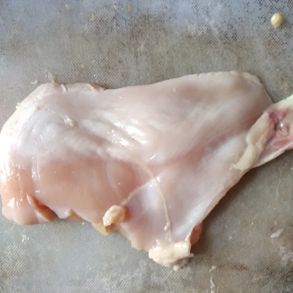 Cuci bersih daging dada ayam, kemudian belah tipis.