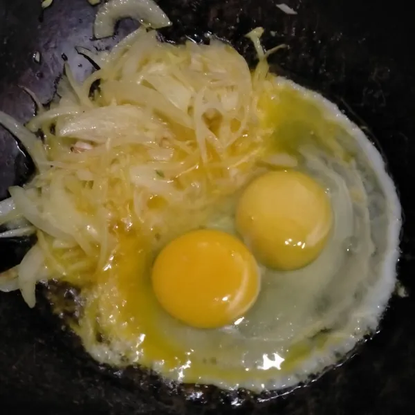 Sisihkan bawang putih dan bawang bombay ke pinggir wajan. Pecahkan telur, buat orak-arik.