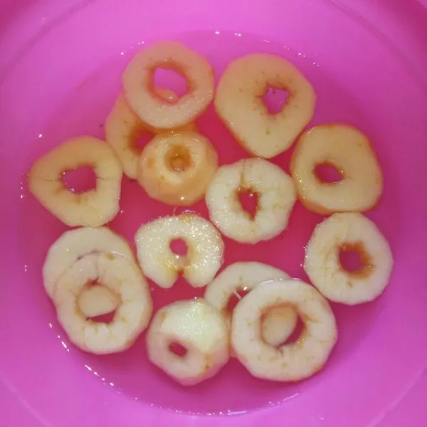 Kupas apel,iris melintang lalu buang bijinya.Rendam apel pada air supaya warna tetap bagus.Direndam selama proses pemotongan selesai.Tiriskan.