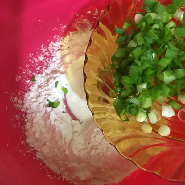 Masukkan daun bawang ke dalam tepung, kemudian aduk rata.