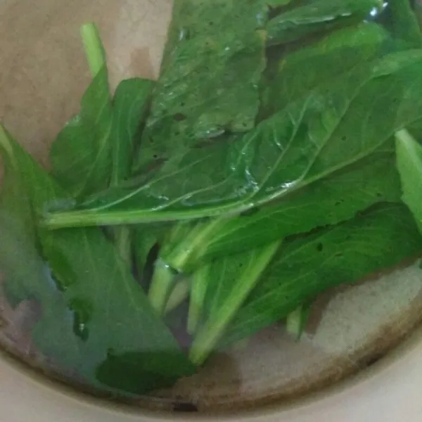 Rebus sawi dalam air mendidih sebentar saja, tiriskan.