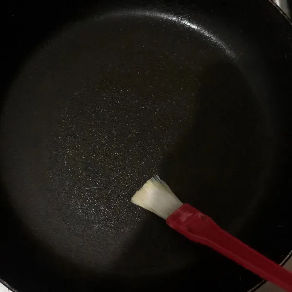 Oleskan mentega di teflon yang sudah dipanaskan menggunakan api kecil.