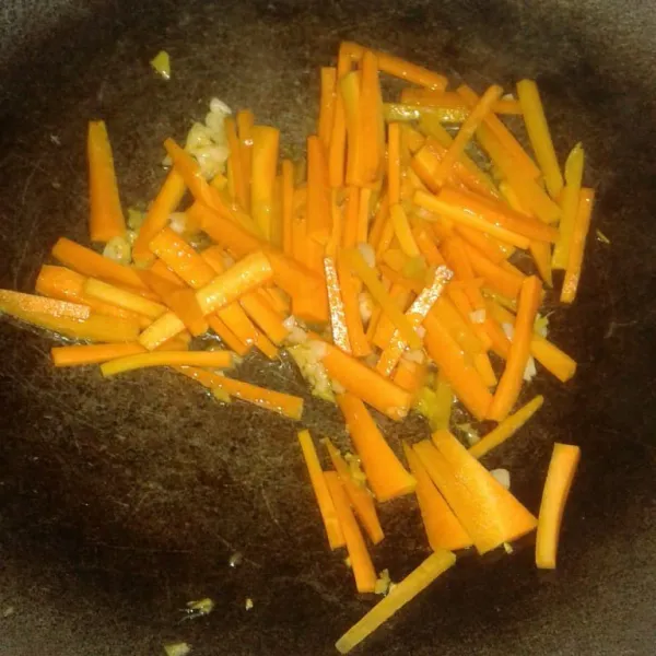 Masukkan wortel, aduk rata dan masak sampai wortel layu.