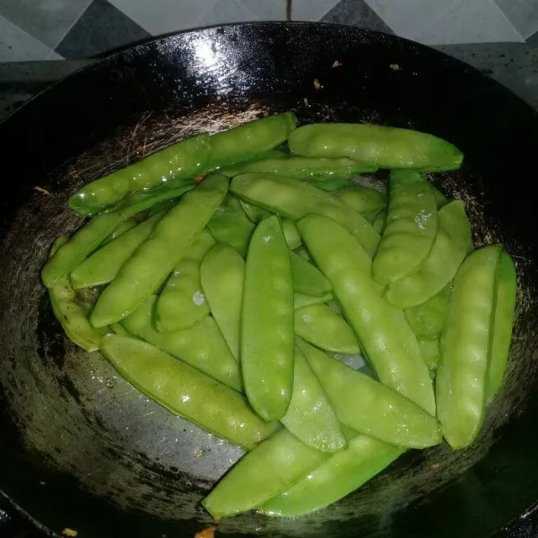 Setelah bawang putih diangkat tumis kapri dengan bekas minyak goreng bawang tadi aduk rata.