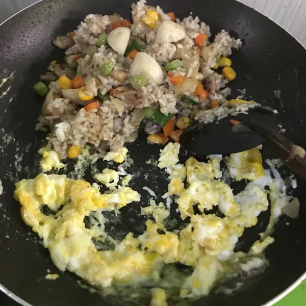 Pada bagian teflon yang kosong, masukkan telur laku orak arik hingga kekuningan, lalu campur rata dengan nasi. Sajikan.