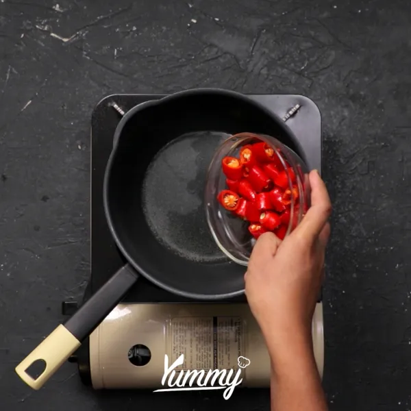 Siapkan minyak lalu panaskan, tambahkan cabai merah, cabai rawit dan tomat.