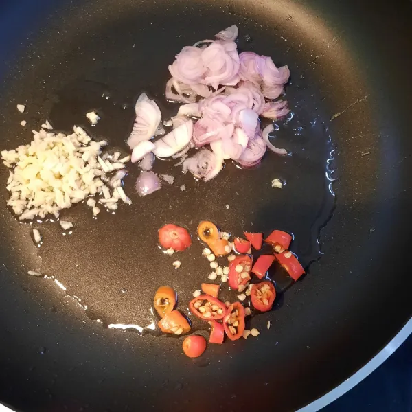 Dengan sisa minyak menggoreng telur, tumis bawang merah, bawang putih, dan cabe rawit hingga harum.
