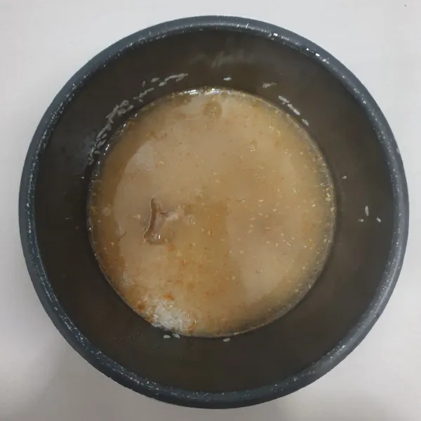 Masukan kedalam panci Rice Cooker, Beras yang telah di cuci bersih, masukan tumisan bawang putih Jahe dan kulit ayam, tuangkan air kaldu ayam (air rebusan ayam tadi), masak nasi seperti biasa.