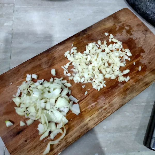 Membuat tumisan ayam: Pertama siapkan bawang putih dan bawang bombay yang sudah dicincang.