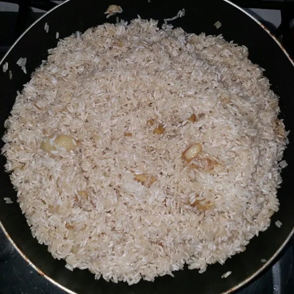 Kemudian masukkan beras, aduk lagi supaya tidak gosong.