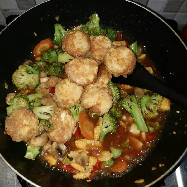 Selanjutnya masukkan tofu goreng dan daun bawang. Aduk rata hingga bumbu meresap. Terakhir masukkan larutan maizena untuk mengentalkan kuahnya. Matikan api, angkat dan sajikan