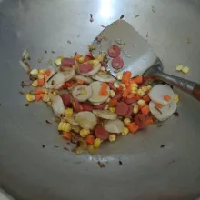 Masukkan baso, sosis, jagung dan wortel. aduk-aduk hingga sayuran layu.