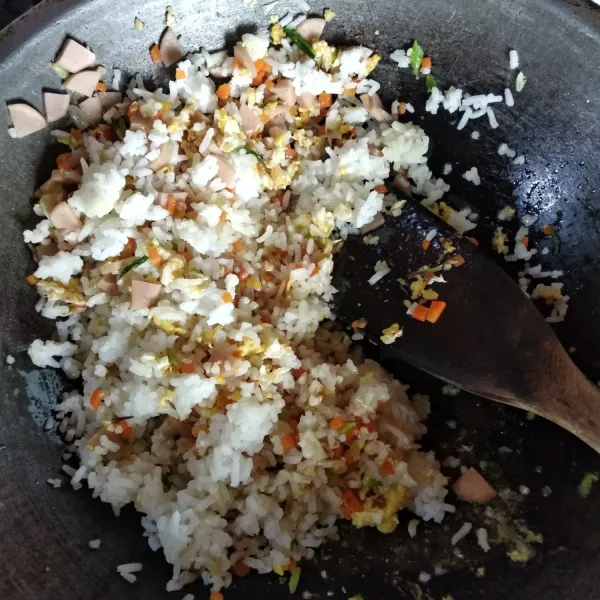 Masukkan nasi putih, aduk-aduk hingga bumbu meresap. Angkat.