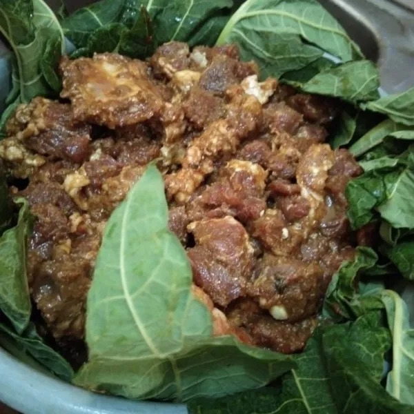 Siapkan wadah baru yang sudah dialasi daun pepaya. Jika daun pepaya nggak ada, bisa di skip. Tapi daun pepaya berguna untuk membuat daging lebih empuk. Tuang daging yang sudah dibumbu dan bungkus dengan daun pepaya. Setelah tertutup dengan daun semua, simpan dalam kulkas minimal 1 jam (lebih lama lebih bagus) agar bumbu bisa meresap sempurna.