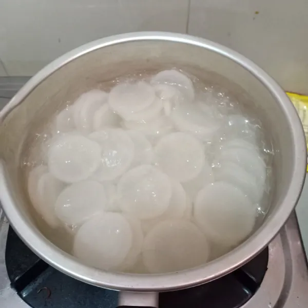 Kupas dan potong-potong lobak. Didihkan air lalu rebus lobak hingga empuk. Buang air rebusan dan tiriskan lobak.