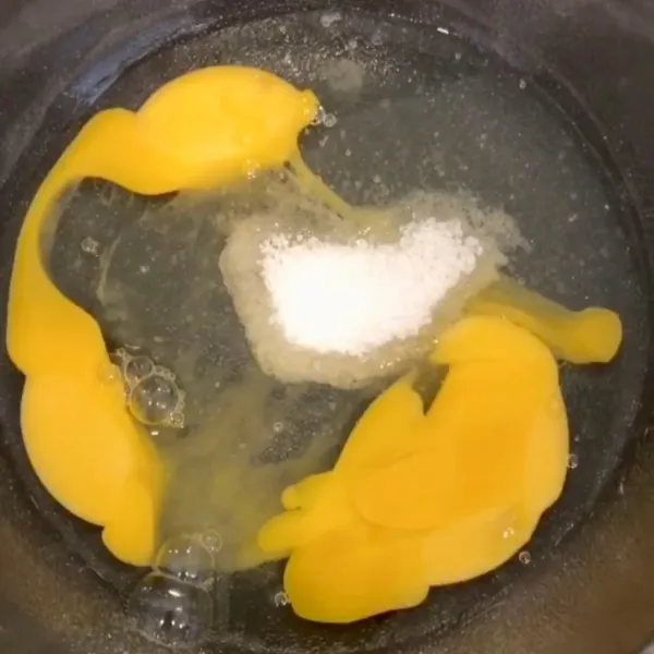 Pecahkan dua butir telur, masukkan 2 sdm gula pasir kemudian kocok hingga mengembang.