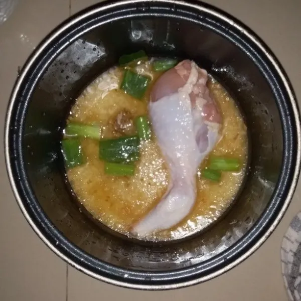 Cuci paha ayam hingga bersih. Kemudian masukan ke dalam panci magic com. Tambahkan potongan daun bawang.