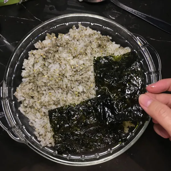Ratakan nasi dalam wadah lalu susun nori di atas nasi.