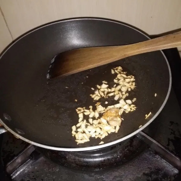 Panaskan minyak wijen/minyak goreng. Tumis bawang putih dan jahe hingga harum. Setelah bawang putih berwarna keemasan, matikan api.