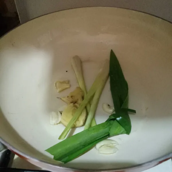 Membuat nasi hainan : tumis bawang putih, jahe, serai dan daun pandan hingga harum.